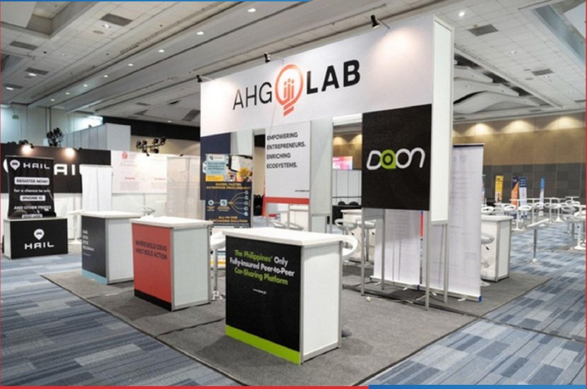 Large booth setup with multiple counters, signage, and shared exhibitor space